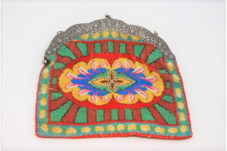 Bolsa de mão em prata no arco relevado com figuras angélicas e motivos florais suportando a bolsa de tecido forrado no interior.